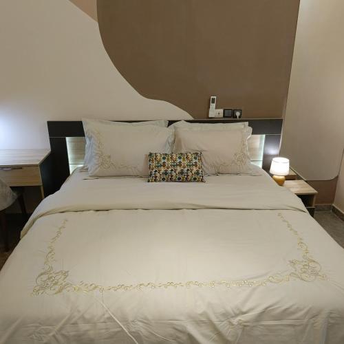 a large white bed with a pillow on it at Le Cocon coloré Work and Chill KÉgué in Avéimé