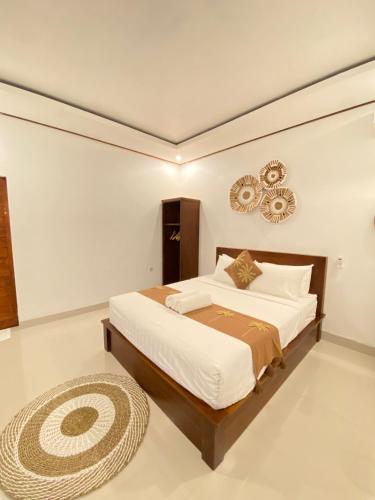 a bedroom with a large bed and a rug at Batur Tropical in Kintamani