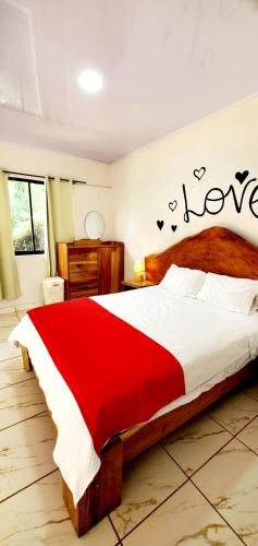 a bedroom with a large bed with a red blanket at Romantic Suite with Pool in Fortuna