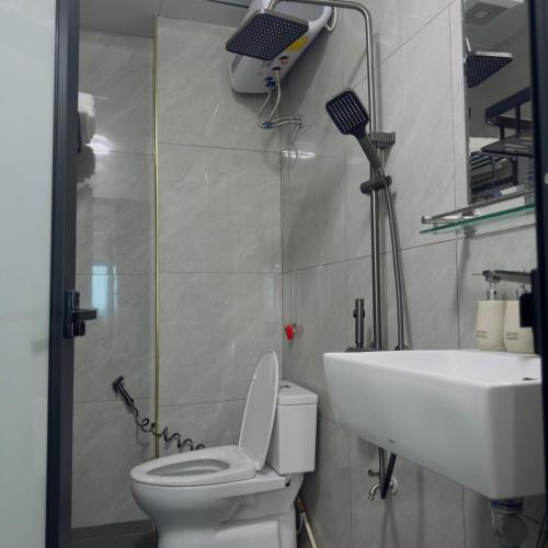 a bathroom with a white toilet and a sink at Queen Hotel in Thạch Cầu