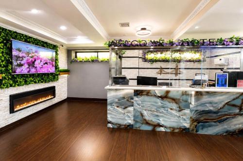 eine Lobby mit Kamin und einem Fernseher an der Wand in der Unterkunft Hotel Pergola Jamaica JFK in Queens