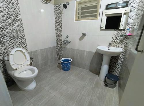 a bathroom with a toilet and a sink at FN's Eternia in Ooty