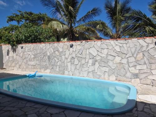 a blue bath tub in front of a stone wall at Arandura Chalés maresias 04 in São Sebastião