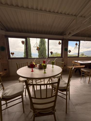 a dining room with a table and chairs and windows at Finca eventos Dalubsu in Silvania