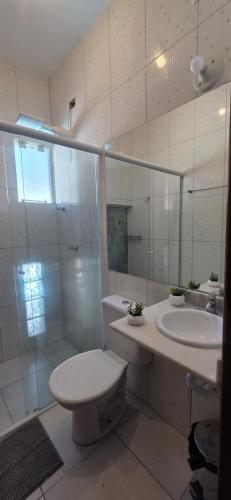 a bathroom with a toilet and a sink and a shower at Arandura Chalés maresias 04 in São Sebastião