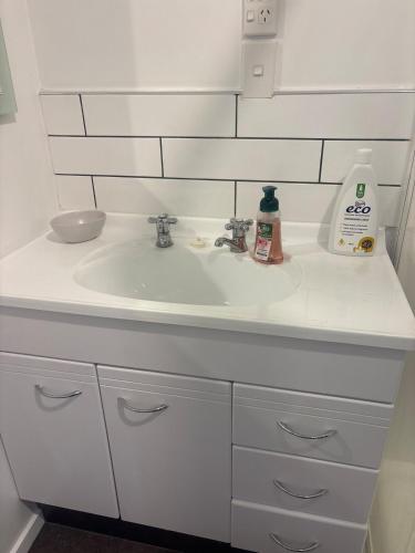 a bathroom sink with a white counter top at Private and comfortable guesthouse in Christchurch