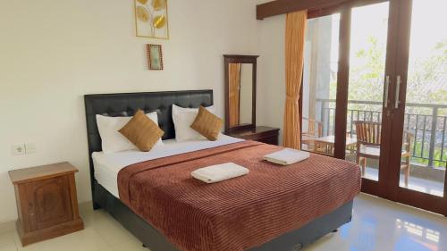 a bedroom with a bed with two towels on it at Waringin Homestay in Kuta