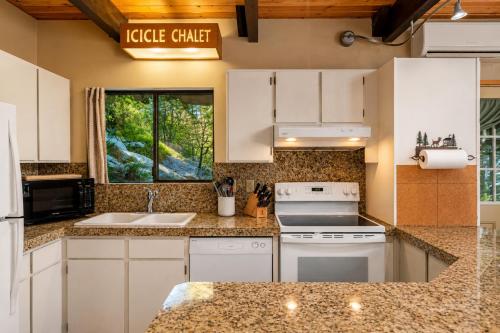 a kitchen with white appliances and a window at Icicle Chalet in Leavenworth