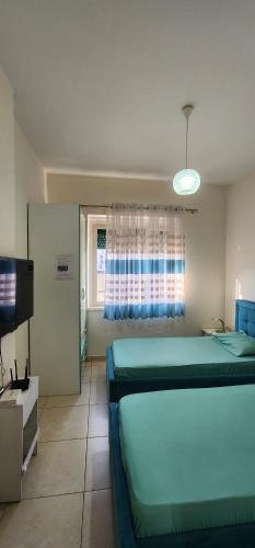 a bedroom with two beds and a flat screen tv at Mali's Apartment in Tirana