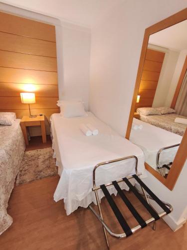 a small room with two beds and a mirror at Flat Aeroporto Congonhas in São Paulo