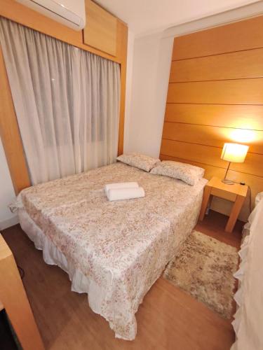 a bedroom with a bed with a book on it at Flat Aeroporto Congonhas in São Paulo