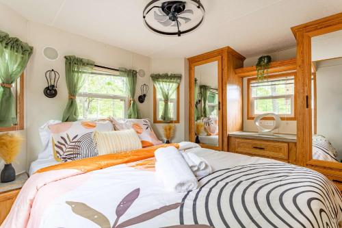 a bedroom with a large bed and a mirror at The Nook Tiny Home Fire Pit Close to Lake in Maple Lake