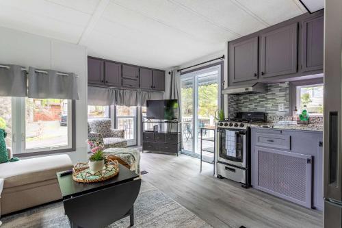 a kitchen and living room with a couch and a table at The Cranny Tiny Home Fire Pit Close to Lake in Maple Lake
