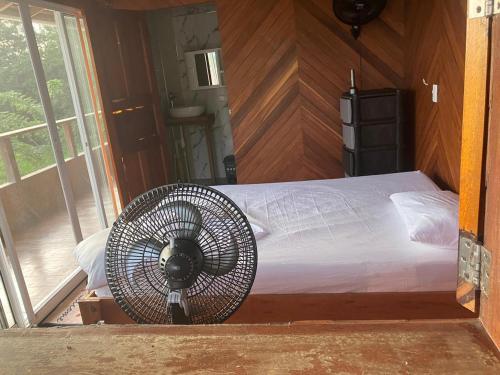 a bedroom with a bed with a fan next to a window at Villa Encanto in Bahía Solano