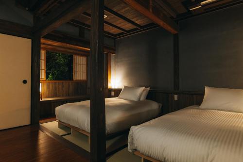 ein Schlafzimmer mit zwei Betten und einem Fenster in der Unterkunft Hotel Raccan in Shibushi