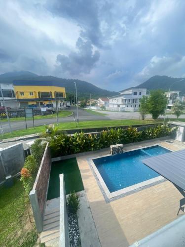 a pool with a wooden deck and a building at Lodge 16 Private Villa in Kuah