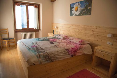 a bedroom with a bed with a wooden wall at Albergo K2 in Madesimo