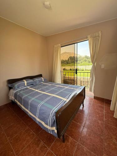 a bedroom with a bed and a large window at Casa los Cipreses del Sol in Cieneguilla