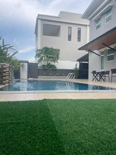 a house with a swimming pool in front of a house at Lodge 16 Private Villa in Kuah
