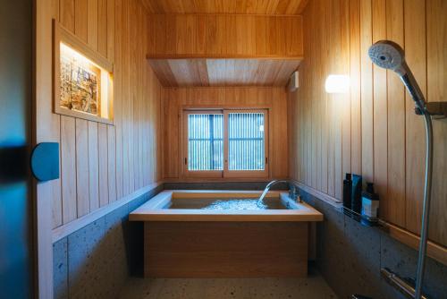 ein Badezimmer mit Badewanne und Dusche in der Unterkunft Hotel Raccan in Shibushi