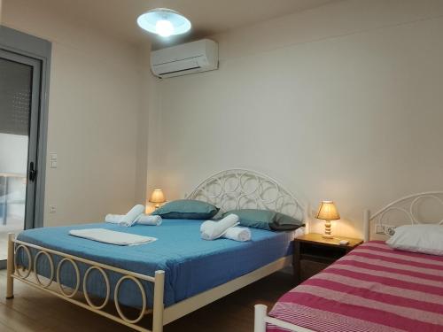 a bedroom with a bed with blue sheets and towels at Makarounis Athanasios Apartments in Petalidi