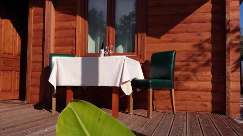 a table and two green chairs on a porch at Sakin Vadi Winehouse in Orhaniye