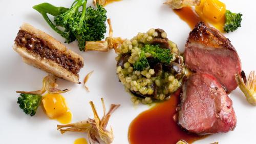 a white plate of food with meat and vegetables at Hensens Residenz in Randerath