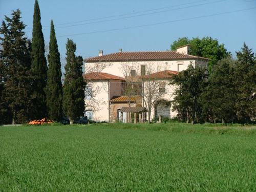 a large house in the middle of a green field at Podere S.Giulia - casale Banditelle in Venturina Terme