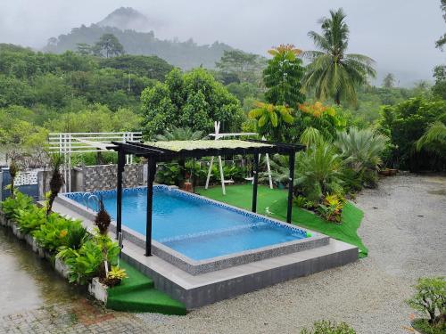 a swimming pool with a gazebo in a garden at Homestay Azkha in Langkawi Islands