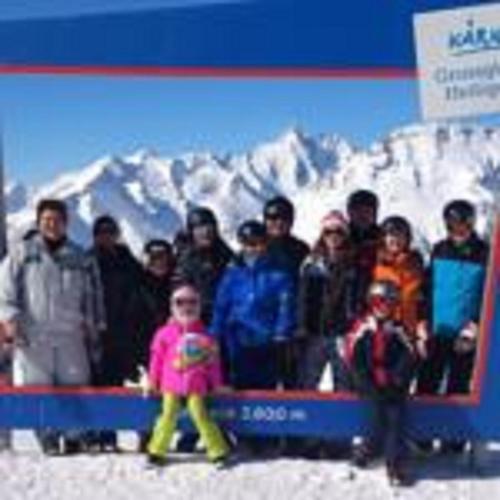 a group of people standing in front of a sign in the snow at Schlosswirt Chalets & Apartments in Großkirchheim