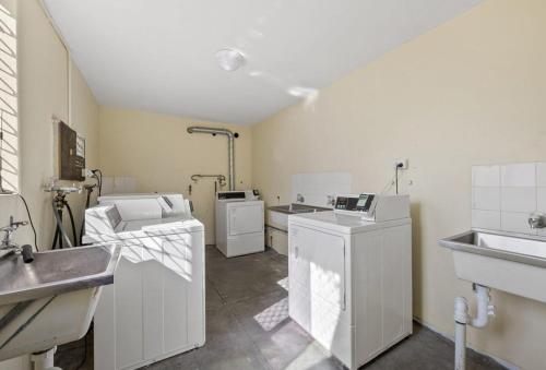 a kitchen with white appliances and a sink at Central Subiaco Oasis 1 Bedroom Unit in Perth
