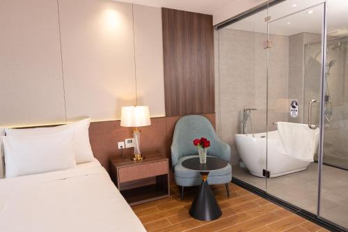 a hotel room with a bed and a bath tub at Devesun Boutique Hotel Phú Quốc in Phú Quốc