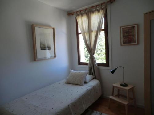 1 dormitorio con cama y ventana en El Artista, en Grazalema