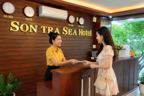 a man and a woman standing at a counter at Sontra Sea Hotel in Danang