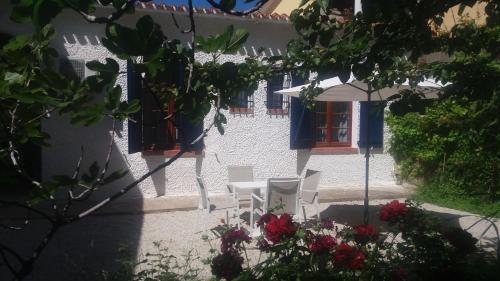 a patio with chairs and an umbrella and flowers at Hotel Meli in Castelsardo