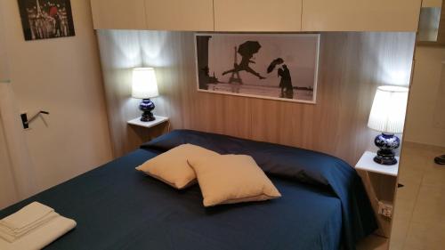 ein Schlafzimmer mit einem blauen Bett mit zwei Lampen in der Unterkunft Aglaia B&B in Gallipoli