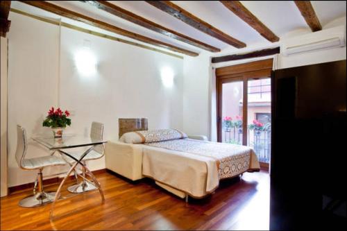 1 dormitorio con cama y mesa de cristal en Sun Studio Valencia, en Valencia