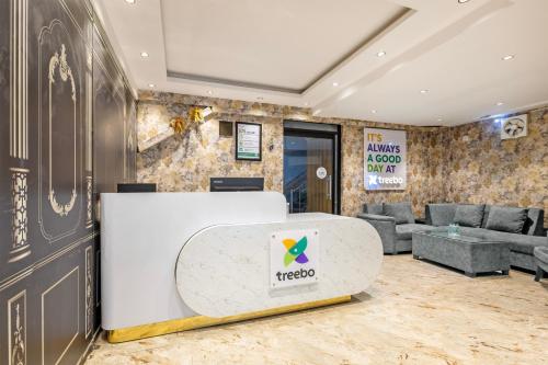 a lobby with a reception desk and couches at Treebo Noida Business Suites in Okhla