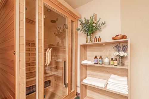 a walk in shower with wooden cabinets and towels at Mržek House with Sauna - Happy Rentals in Nova Vas