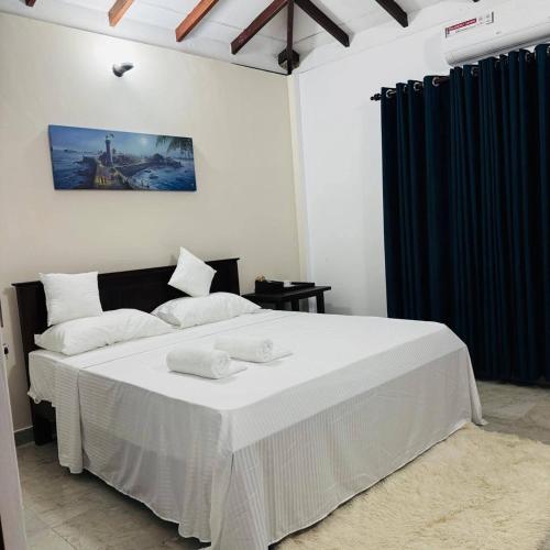 a bedroom with a bed with two towels on it at Boom Town Villa - Anuradhapura in Anuradhapura