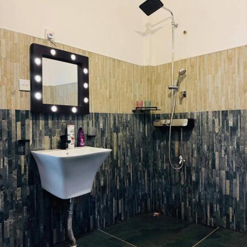 a bathroom with a sink and a mirror on the wall at Boom Town Villa - Anuradhapura in Anuradhapura