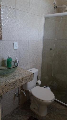 y baño con aseo, lavabo y ducha. en Casa Arraial do Cabo, en Arraial do Cabo