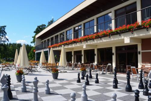 a chess board in front of a building with tables and chairs at Domki Kaszuby - jezioro las i zoo w Szarlocie in Kościerzyna