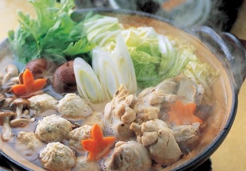 a bowl of soup with mushrooms and vegetables on a table at Hotel Utopia in Yuzawa