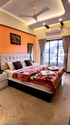 a bedroom with a large bed with an orange wall at Omkar Hotel - Mahabaleshwar in Panchgani