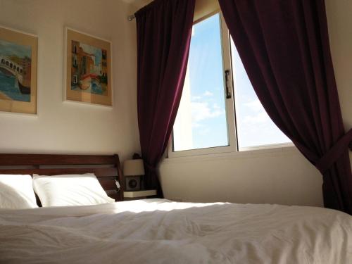 una camera da letto con un letto e una finestra di Panoramic Eden a Paphos