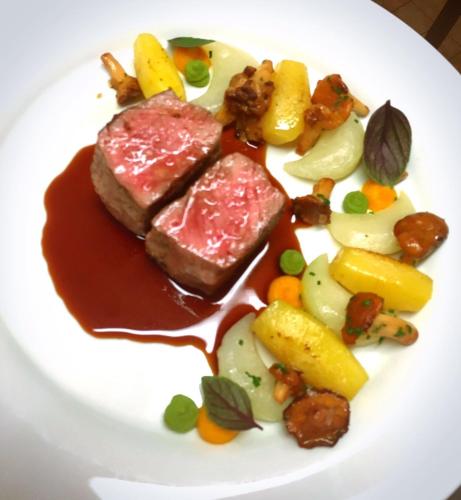 a plate of food with meat and vegetables on it at Romantik Waldhotel Mangold in Bergisch Gladbach