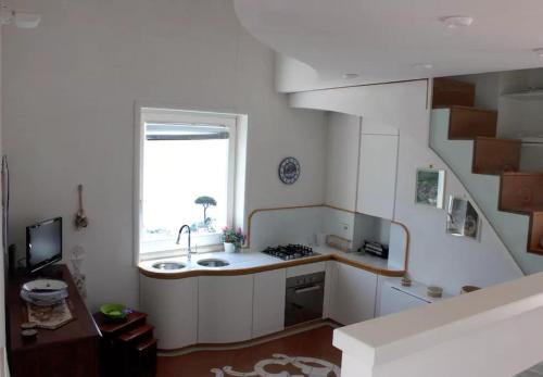 uma pequena cozinha com um lavatório e uma janela em La Torre em Ravello