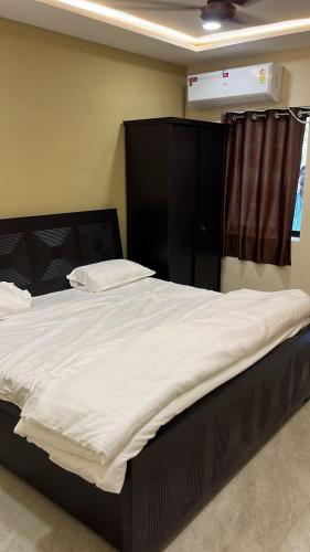 a bedroom with a large bed with white sheets at DownTown INN in Manendragarh