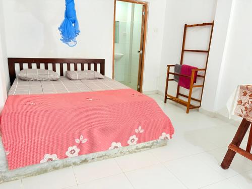 a bedroom with a bed with a pink blanket at Villa 64 - Airport Transit in Katunayaka